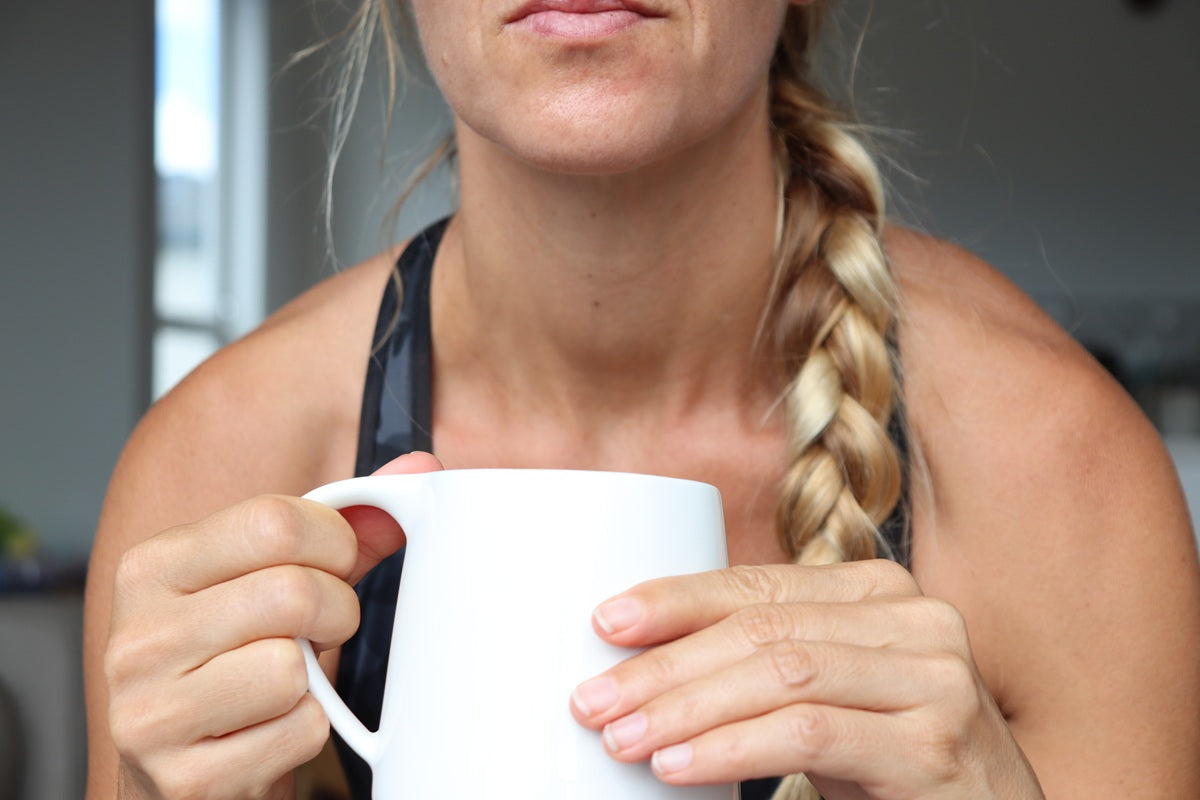 Janet holding a white mug of green tea
